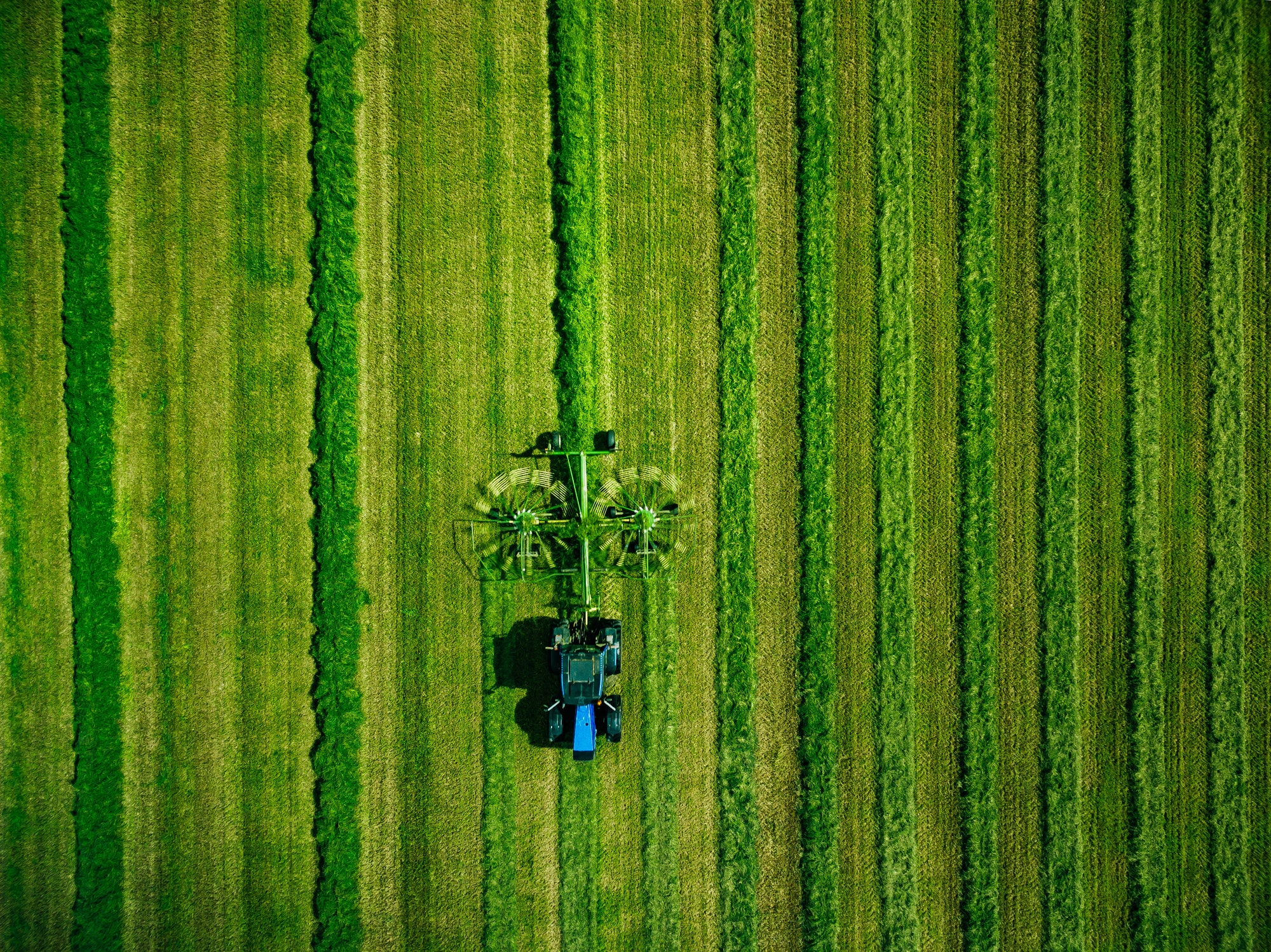 aerial view of tractor mowing green field in finland