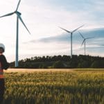 Engineer working at alternative renewable wind energy farm - Sustainable energy industry concept