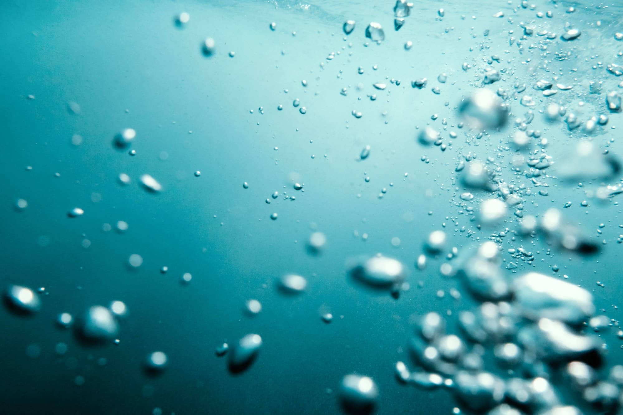 underwater view of bubbles in deep blue ocean close up water background